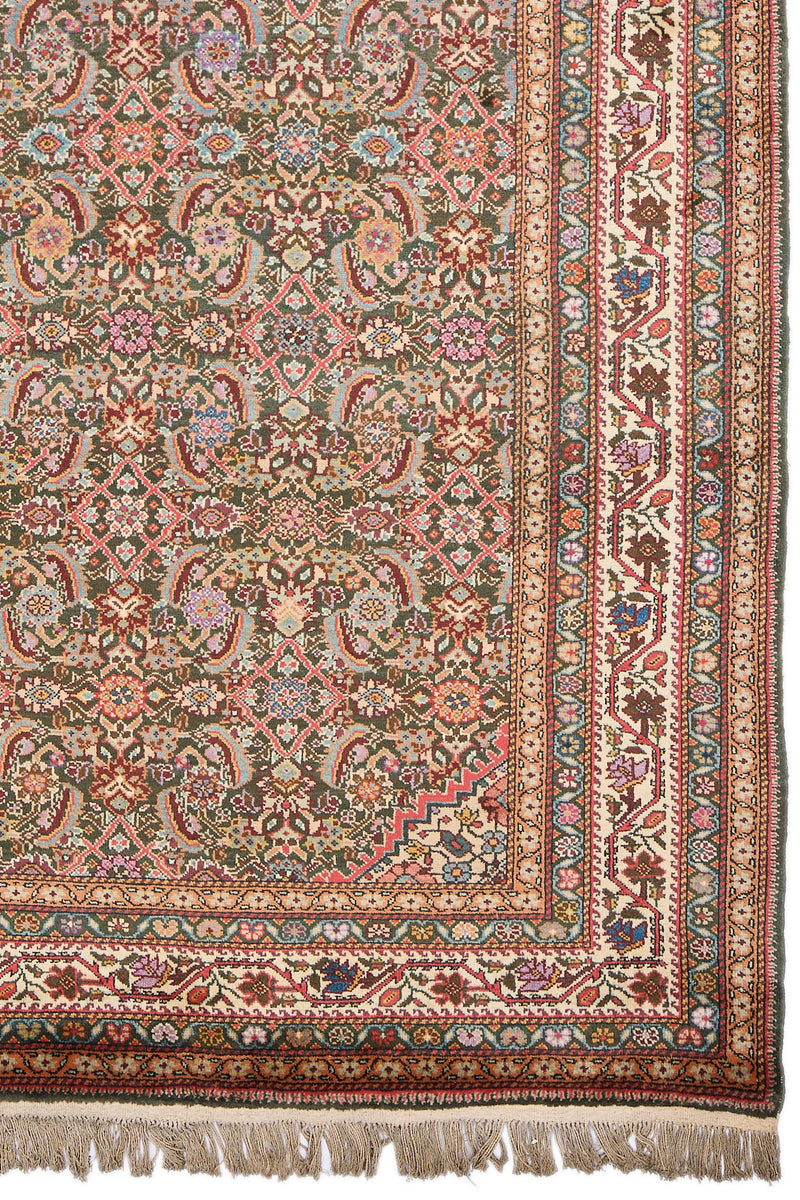 Detalle inferior derecho de alfombra con diseño floral en rosa, lavanda, celeste y bordes marfil con motivos botánicos.