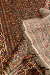 Detalle de la esquina doblada de la alfombra mostrando el reverso del tejido y flecos claros junto a los vibrantes colores del diseño.