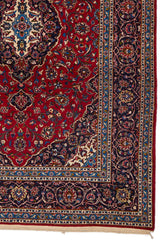 Detalle inferior derecho de la alfombra, mostrando el borde azul celeste con flores estilizadas y arabescos en tonos marfil y rojo oscuro.