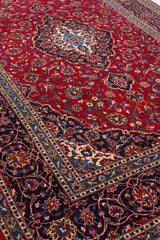 Vista lateral de la alfombra con énfasis en la combinación de colores: rojo vibrante, azul marino, marfil y toques de amarillo.