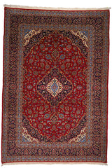 Vista completa de una alfombra persa con fondo rojo intenso y medallón central azul claro rodeado de flores marfil y azul marino.
