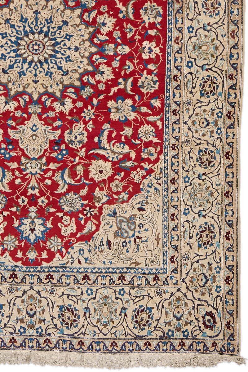 Detalle del borde derecho de la alfombra, mostrando flores beige, azul celeste y marrón sobre fondo marfil y parte del medallón central.