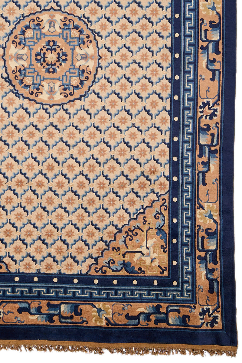 Detalle del medallón central azul y beige de la alfombra persa, rodeado por patrones geométricos estrellados sobre fondo beige.