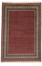 Vista completa de la alfombra persa con fondo rojo oscuro y patrón repetitivo de motivos florales, enmarcada por guardas crema y azul con figuras geométricas.