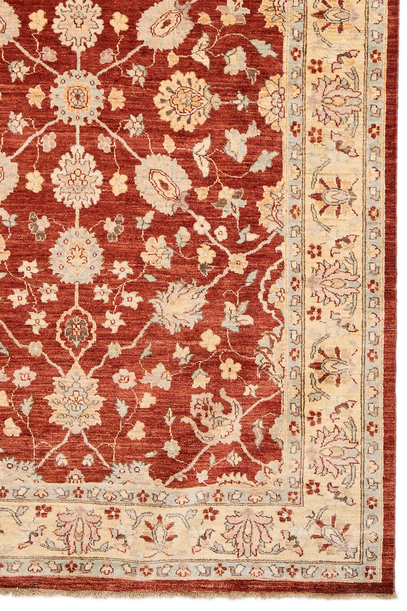 Detalle del borde inferior derecho que muestra el patrón floral y la transición entre los colores principales de la alfombra.