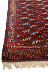 Toma en ángulo bajo que resalta la textura y la intensidad de los colores de la alfombra especialmente los motivos en rojo y azul profundo.