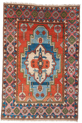 Vista superior completa de una alfombra Kazak con diseño geométrico y tonos predominantes de rojo, azul y beige.