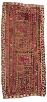 Vista completa de una alfombra kilim con diseño geométrico tribal en tonos tierra, burdeos y marrón oscuro.