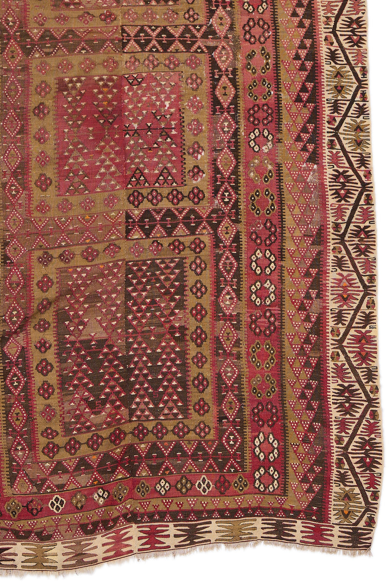 Detalle inferior derecho de la alfombra kilim, mostrando motivos en forma de rombos, triángulos y flores estilizadas.