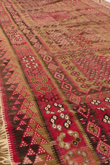 Perspectiva lateral de la alfombra kilim, resaltando la textura plana del tejido y los colores apagados de inspiración natural.