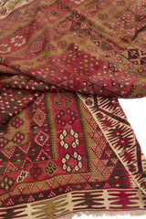 Esquina doblada de la alfombra kilim, revelando el reverso y evidenciando la técnica tradicional de tejido plano.