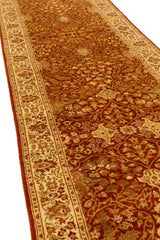 Perspectiva diagonal de alfombra persa con fondo marrón rojizo y bordes crema decorados con flores en tonos tierra