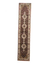 Alfombra oriental de forma alargada con fondo marrón oscuro, decorada con una sucesión de medallones centrales color marfil y detalles en rojo, verde, negro y azul.