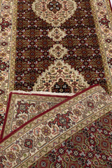 Detalle del reverso de la alfombra con la textura del tejido visible, exhibiendo la calidad de la confección artesanal y la intensidad de los colores.