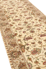 Vista diagonal en perspectiva mostrando el relieve del diseño floral en alfombra beige.