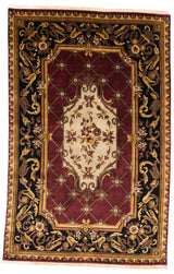 Alfombra clásica con diseño floral central en tonos burdeos y beige sobre un fondo negro.