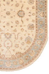 Detalle inferior derecho de la alfombra mostrando el contraste entre el centro beige y la guarda azul celeste con flores estilizadas.