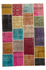 Alfombra patchwork rectangular compuesta por retazos de distintos colores y patrones, incluyendo fucsia, verde, mostaza y negro.