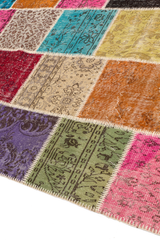 Vista en ángulo de la alfombra patchwork, mostrando la diversidad de texturas y la costura que une cada retazo.