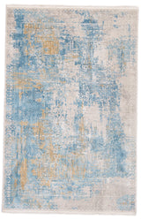 Vista superior completa de una alfombra rectangular con fondo claro, detalles en azul celeste y toques dorados, de diseño desgastado.