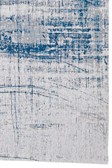Detalle del diseño abstracto de la alfombra, destacando el contraste entre el azul vibrante y los tonos neutros.