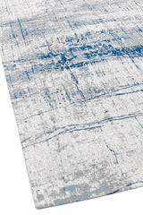 Vista cercana del borde de la alfombra, resaltando las líneas abstractas y la mezcla equilibrada de colores.