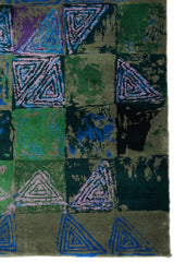 Detalle de los patrones triangulares lilas sobre fondo verde oscuro y verde brillante.