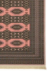 Detalle del borde lateral derecho de la alfombra, mostrando los patrones entrelazados y los colores en contraste sobre fondo rosa.