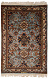 Vista superior de una alfombra oriental con fondo celeste y complejo diseño floral y geométrico.