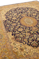 Vista angular de la alfombra persa mostrando la transición entre el centro floral oscuro y la guarda dorada.