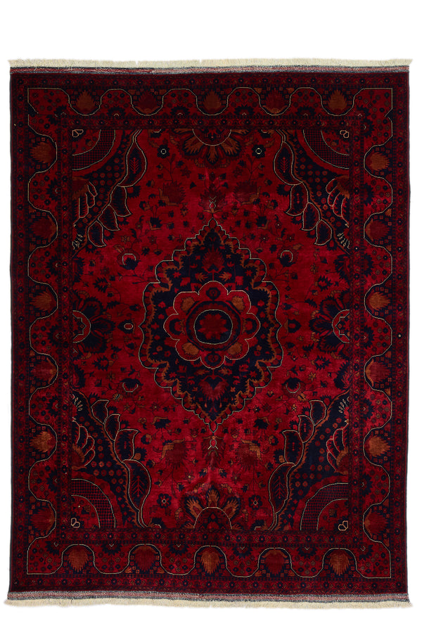 Alfombra persa con fondo rojo intenso y medallón central azul oscuro con detalles en rojo y dorado, vista completa desde arriba.