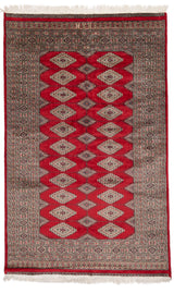 Alfombra oriental con fondo rojo vibrante y patrones geométricos en forma de rombos dispuestos en filas simétricas.