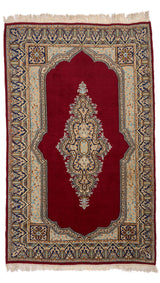 Vista completa de alfombra oriental con fondo rojo intenso y medallón central en tonos beige, celeste y azul.