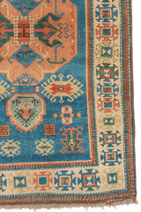 Detalle del borde inferior derecho de la alfombra, mostrando patrones tribales y diseño simétrico en la guarda.