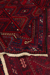 Detalle de esquina levantada de alfombra oriental revelando parte del reverso tejido y flecos claros