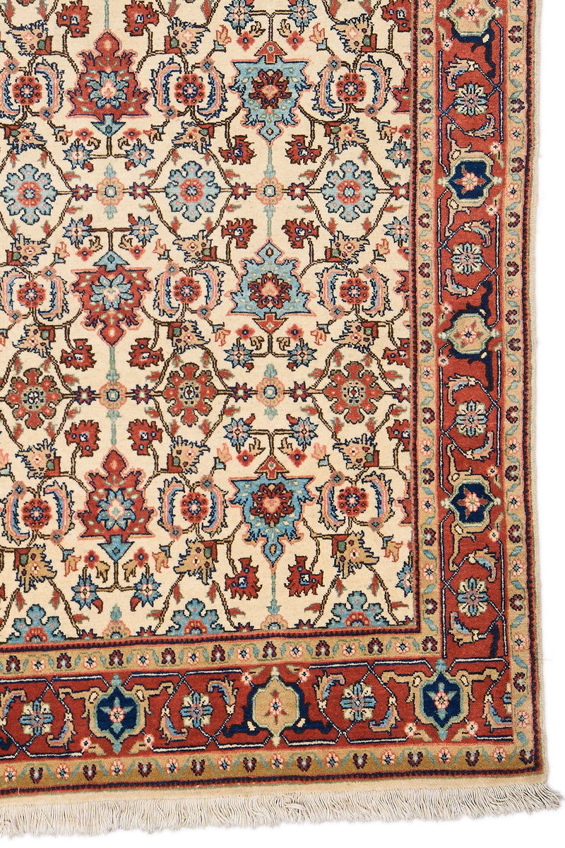 Detalle inferior derecho de la alfombra mostrando bordes decorativos en terracota con motivos florales estilizados.