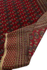 Reverso de la alfombra oriental roja doblado para mostrar la textura y el diseño de la parte trasera.