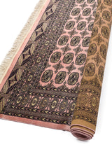 Alfombra oriental con base roja y detalles florales en beige, con borde de color crema.