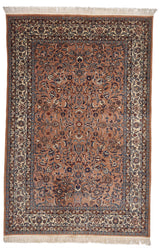 Alfombra persa en tonos marrón claro con detalles florales y guarda beige.