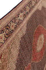 Vista inclinada de la alfombra persa mostrando la calidad de los bordes decorativos.