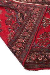 Reverso de alfombra persa roja mostrando la calidad del tejido y los detalles del borde.
