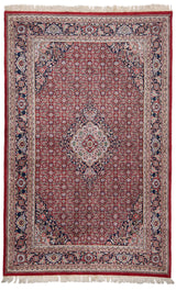 Vista completa de una alfombra de fondo rojo con intrincados detalles geométricos y florales en tonos beige, azul y verde.