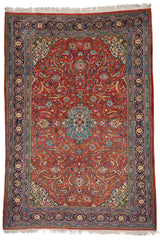 Alfombra persa completa con un elaborado diseño floral sobre un fondo rojo, enmarcado por un borde azul decorado