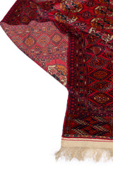 Detalle de la parte posterior de una alfombra oriental roja, resaltando la calidad de los tejidos y los patrones geométricos.