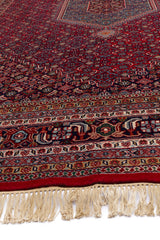 Vista lateral de la alfombra persa destacando la transición de los colores y la textura suave del tejido.