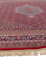Detalle del borde de la alfombra persa con un enfoque en la franja decorativa y los flecos en el extremo.