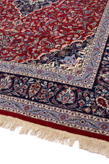 Alfombra oriental con motivos florales en tonos beige, azul y marrón.