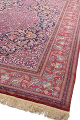 Vista en ángulo de la alfombra persa mostrando la textura y la riqueza de los detalles florales.