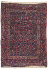 Vista completa de una alfombra persa con un diseño floral y geométrico intrincado, en tonos ricos de rojo y azul.