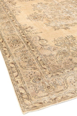 Detalle de la alfombra con su esquina ligeramente doblada, mostrando el reverso y los patrones ornamentales.